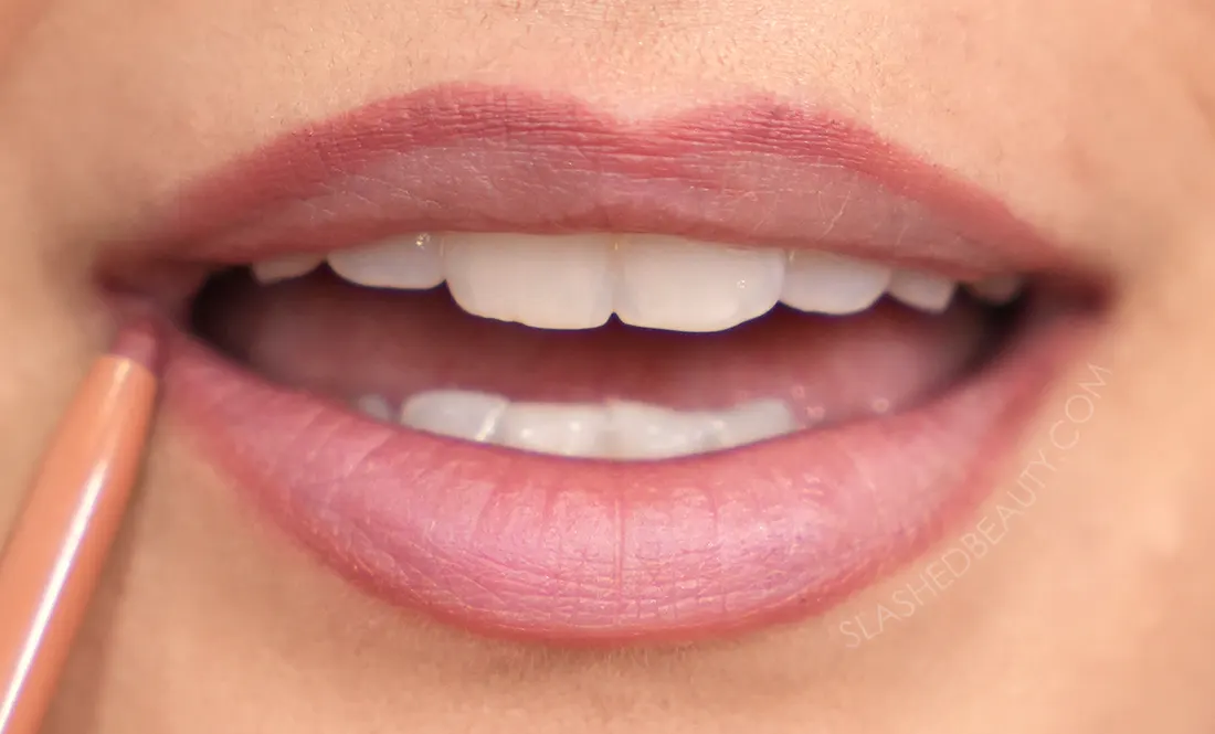 Close up of lips with lip liner drawn on the top and bottom lip edges. | How to Make Your Lips Look Bigger with Makeup | Slashed Beauty