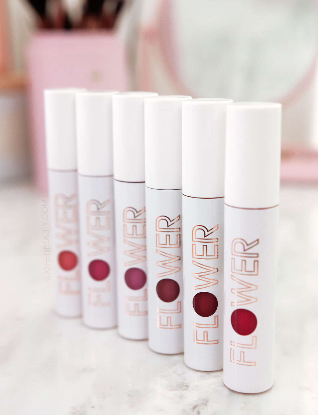 Closed tubes of Flower Beauty Bitten Lip Stain standing side by side on a vanity | Flower Beauty Bitten Lip Stains Review & Swatches | Slashed Beauty