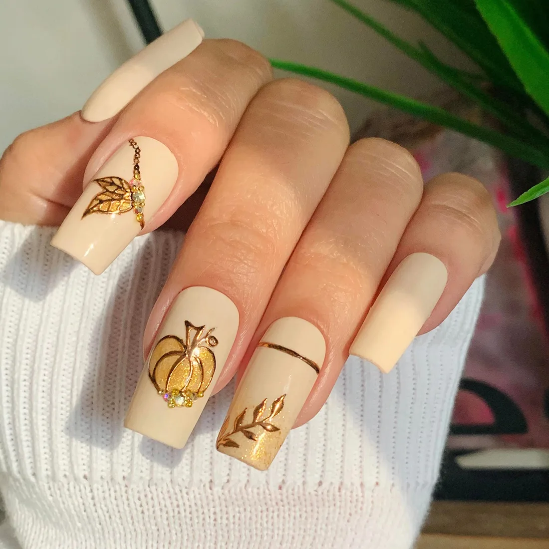 Cream beige nails with gold accents in leaf and pumpkin designs | Trendy Fall Nail Designs You Can Buy as Press-Ons on Etsy | Slashed Beauty