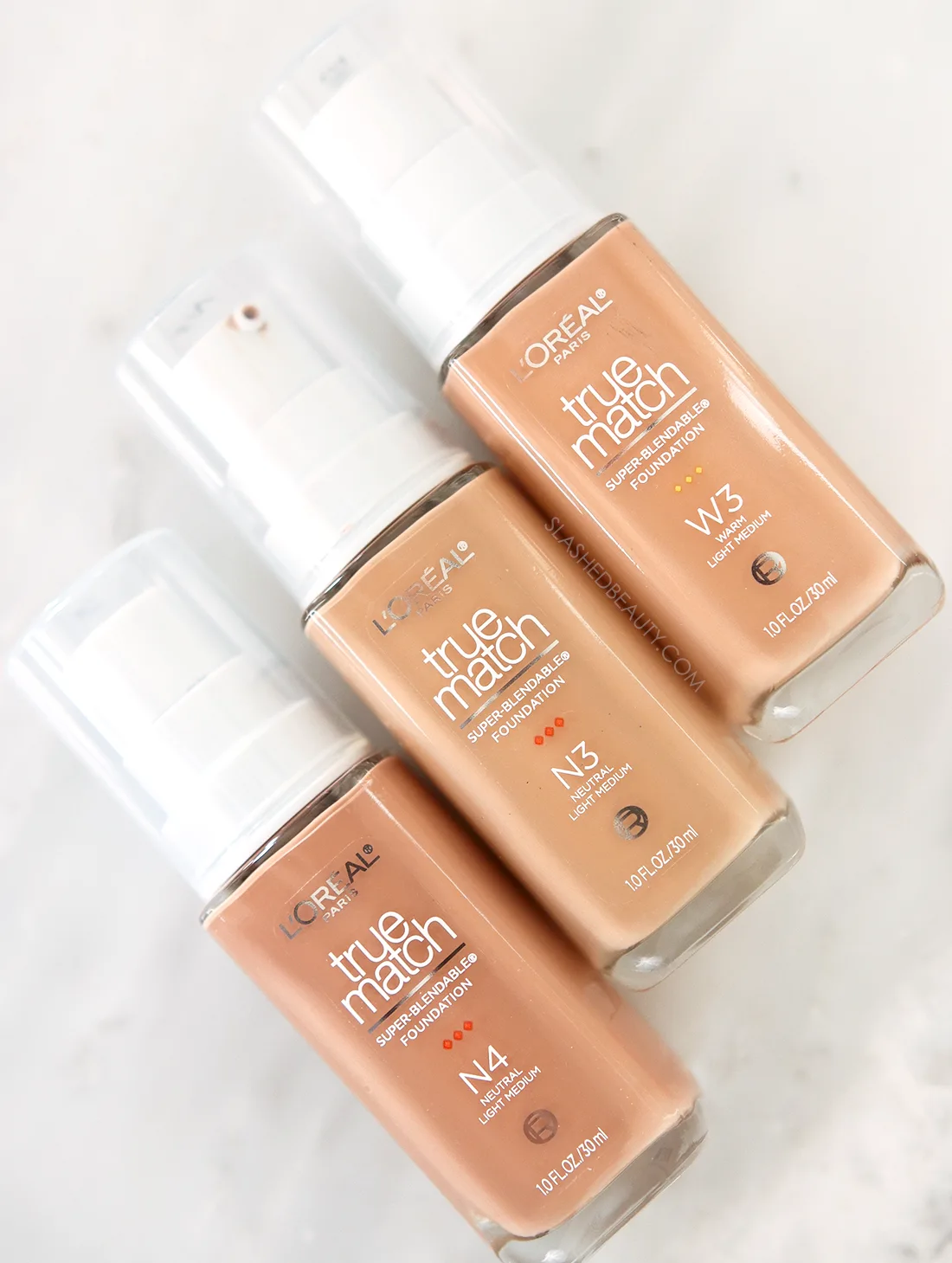Three bottles of the L'Oreal True Match Super Blendable Foundation lying flat | NEW L'Oreal True Match Foundation Review 2023 | Slashed Beauty