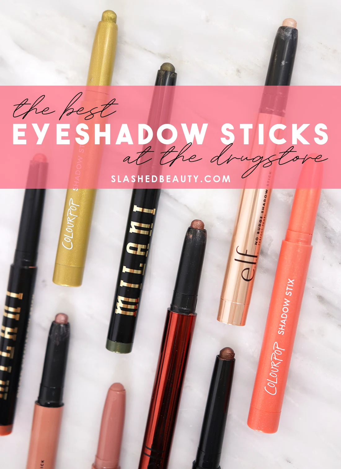 Various drugstore cream eyeshadow sticks lying on a marble surface with text overlay: The Best Eyeshadow Sticks at the Drugstore | Slashed Beauty