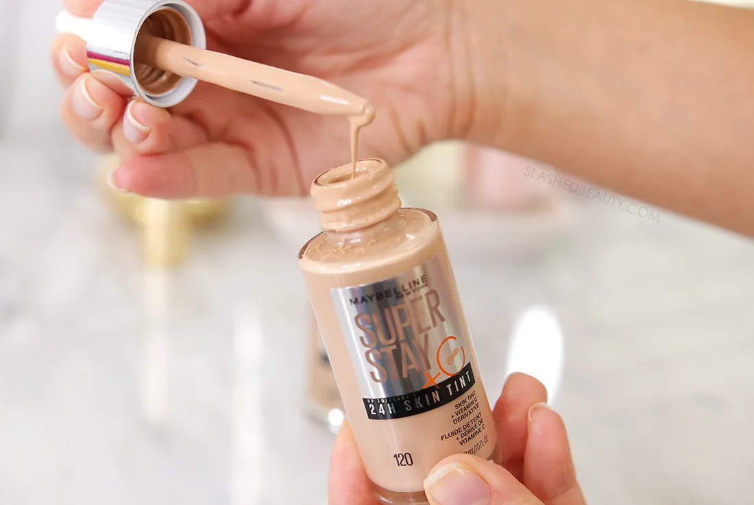 Hands holding a bottle of Maybelline SuperStay Skin Tint | The 5 Best New Drugstore Beauty Finds of 2023 | Slashed Beauty
