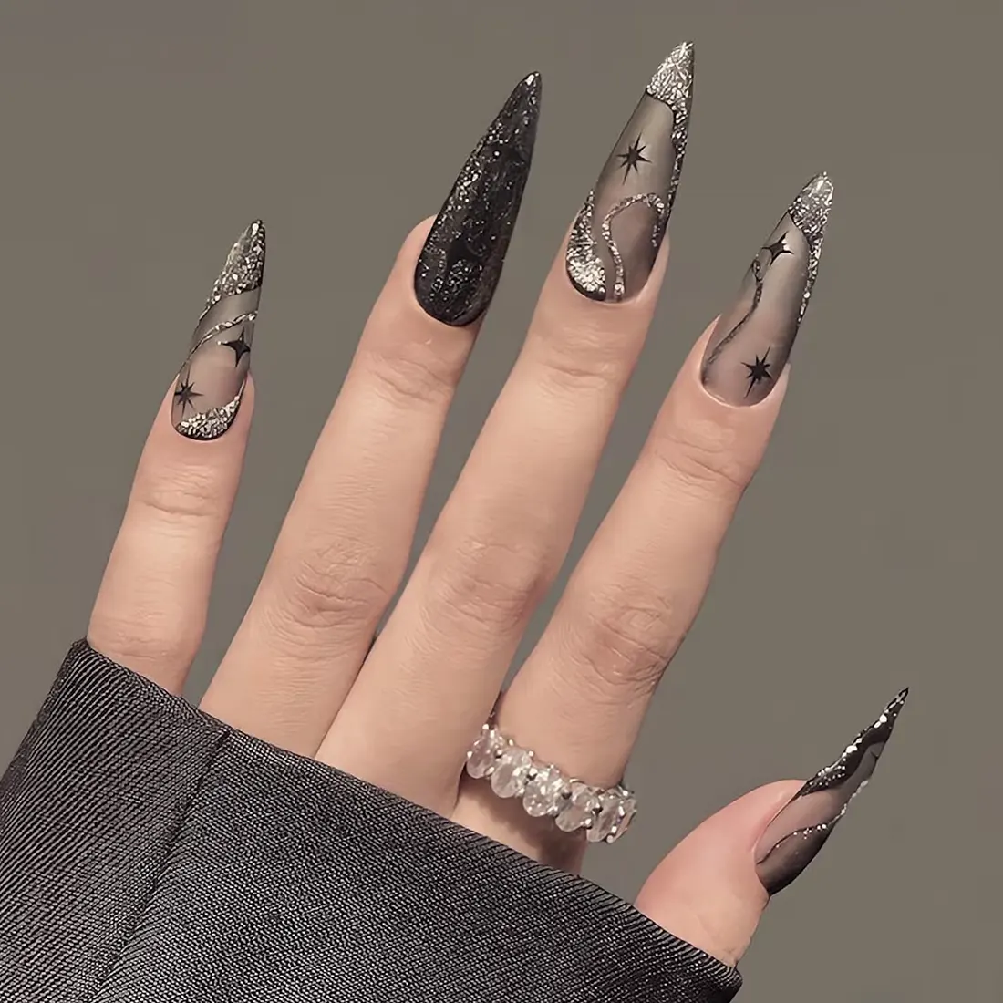 Closeup of long stiletto nails with black and silver star designs | 9 Witchy Nail Designs You Can Buy as Press-Ons on Etsy | Slashed Beauty