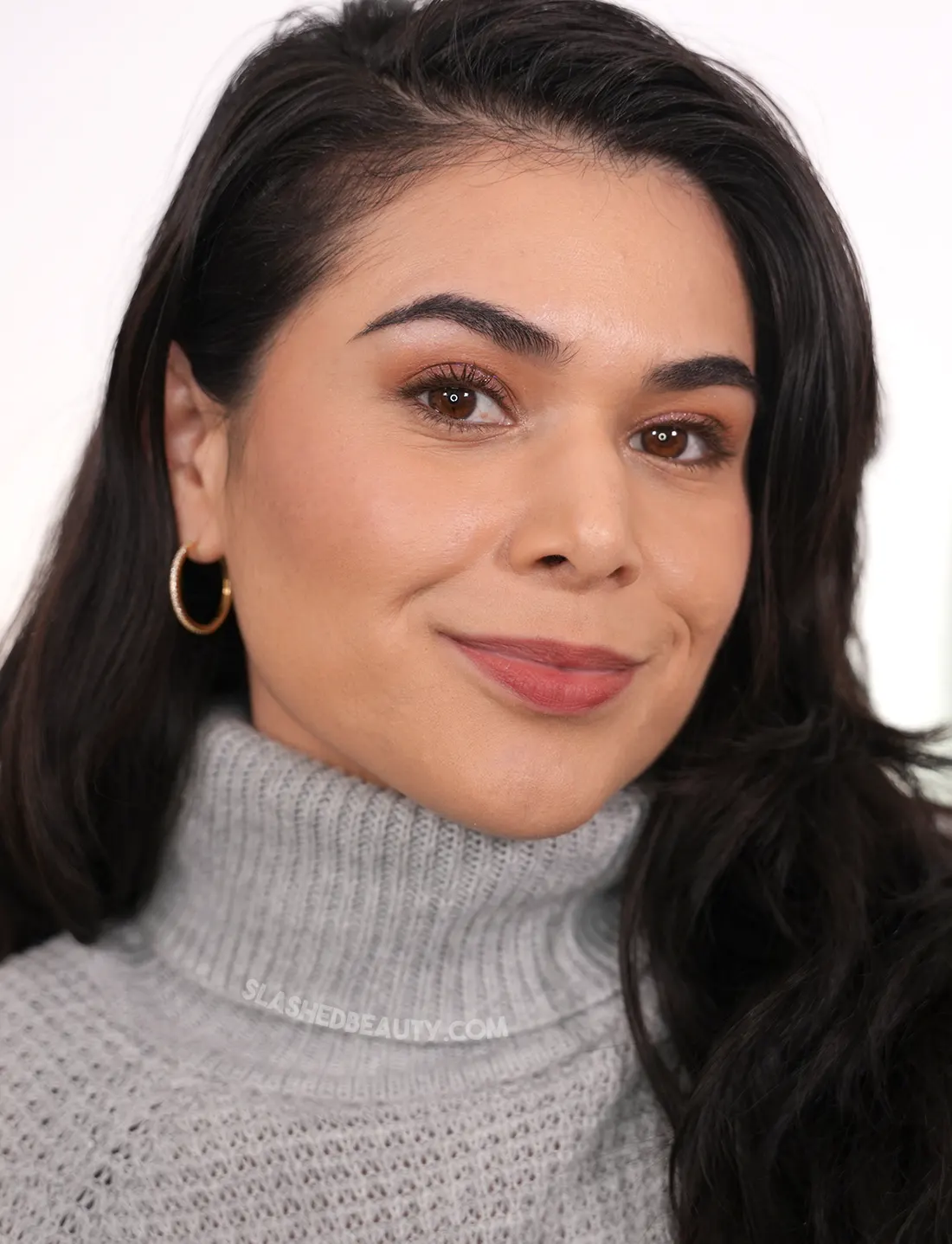 Miranda looking to camera wearing the Maybelline Super Stay Teddy Tint in Skinnydip as blush and lip color. | Slashed Beauty 