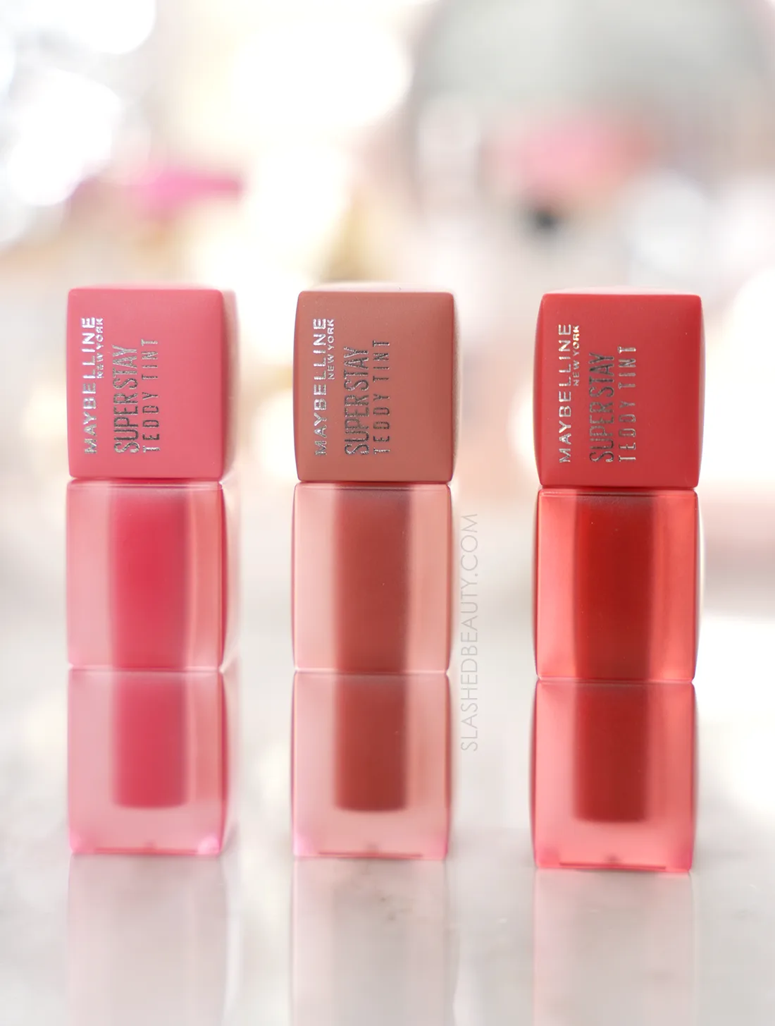 Three tubes of Maybelline Super Sty Teddy Tints standing side by side on a marble surface | Slashed Beauty