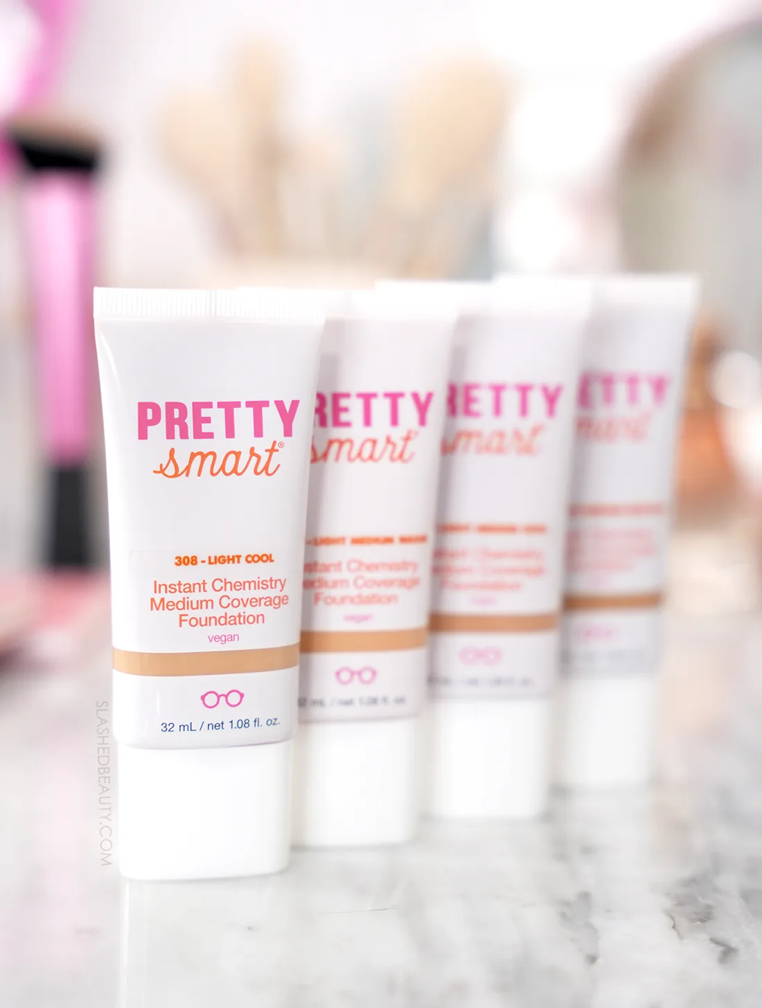 Four tubes of Pretty Smart Instant Chemistry Foundation standing side by side on a marble vanity | Slashed Beauty